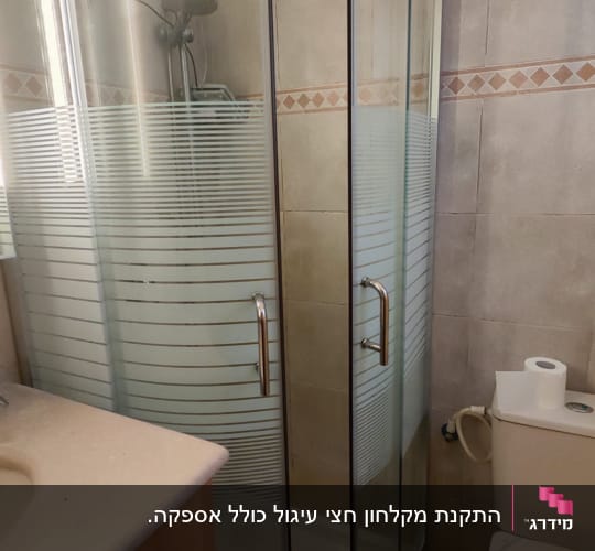 מקלחון פינתי מעוגל עם דלתות הזזה וזכוכית מעוטרת בחדר רחצה